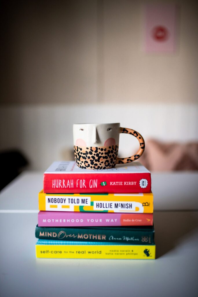 Anthropologie Mug atop a pile of books on Motherhood