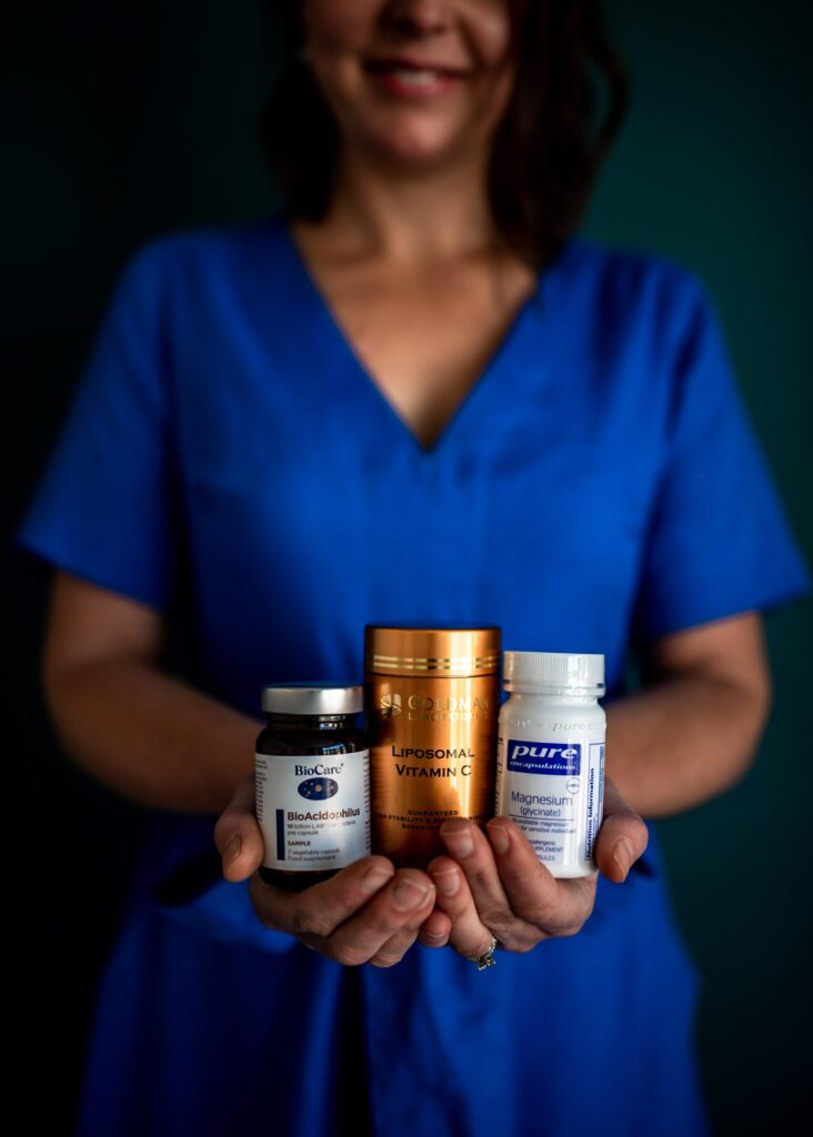 Close-up of supplements being held by a nutritionist in the background