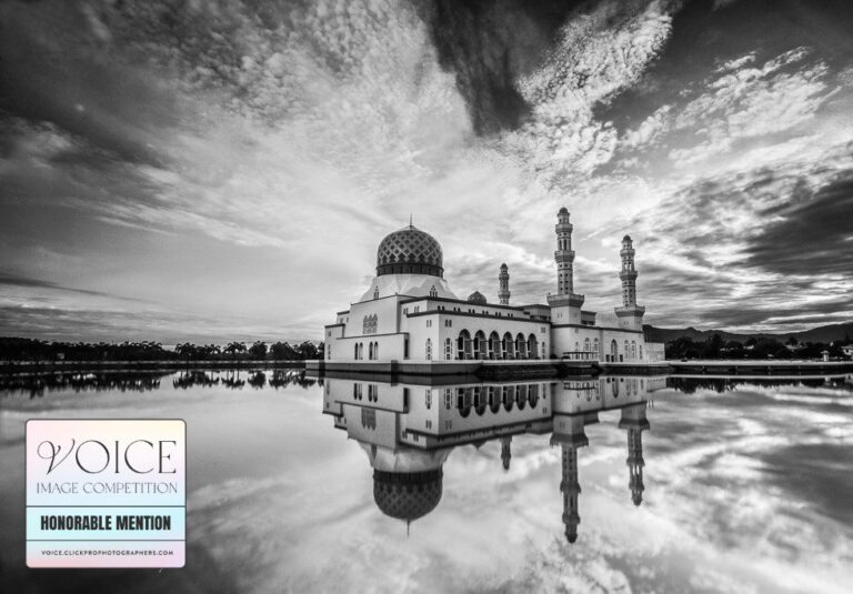 Grand Mosque in front of a dramatic cloudy sky in Malaysian Borneo, reflected in the water. Edited in black and white.